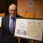 Inductee Harvey Graham with his portrait.