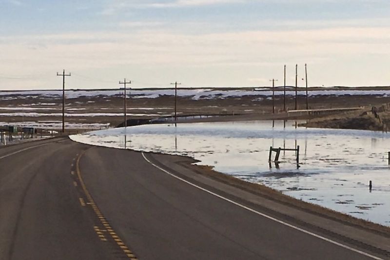 Cattle producers and feeders in some areas of southern Alberta have been dealing with overland flooding, such as shown here Saturday over Highway 36 south of Vauxhall, and otherwise mushy conditions. (Photo courtesy Taber RCMP)

