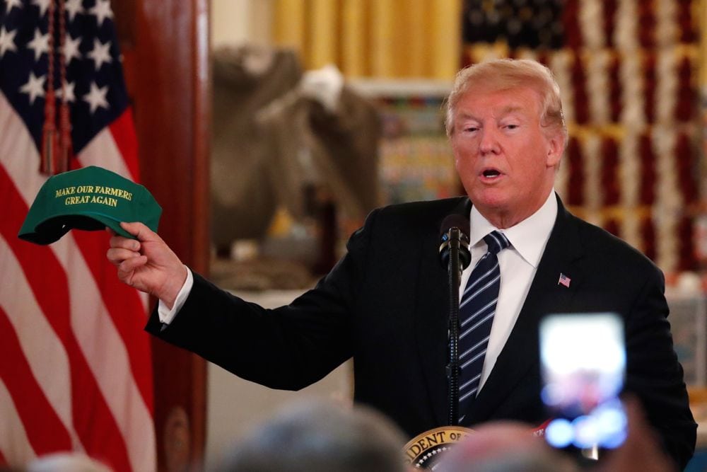 U.S. President Donald Trump holds up a cap reading “Make Our Farmers Great Again” while delivering remarks at a showcase of U.S.-made products at the White House in Washington on July 23, 2018. (Photo: Reuters/Carlos Barria)
