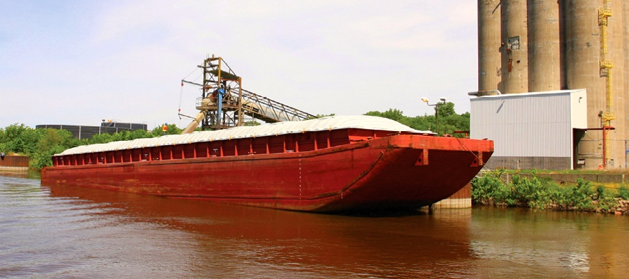 A barge loads on the Mississippi River. American soybeans aren’t moving to China, even though they are price competitive with Brazil.