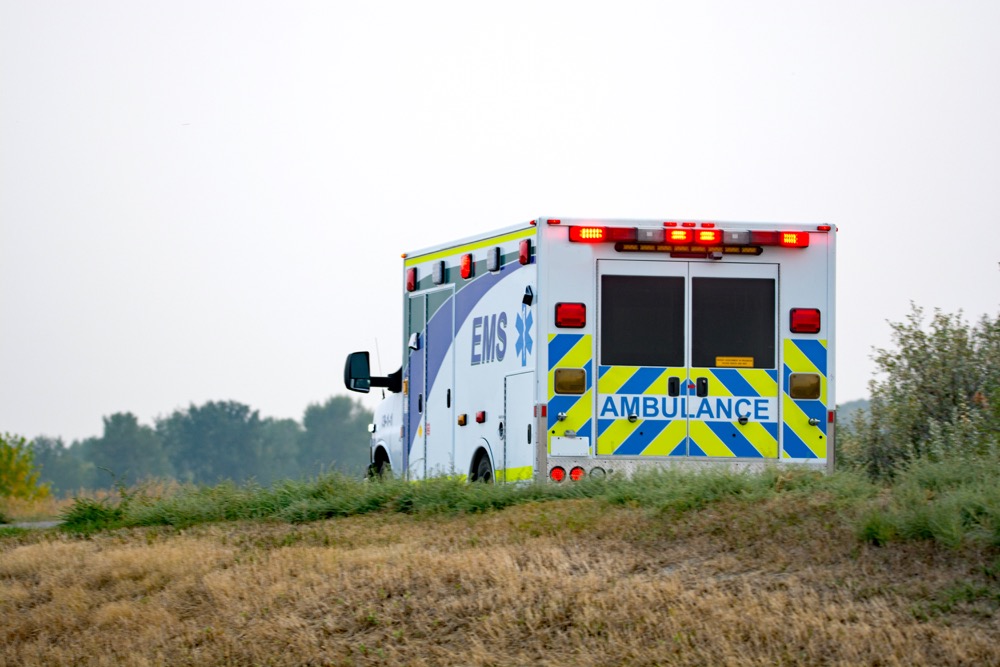 Ambulance on rural road with warning lights