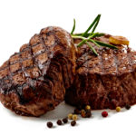 grilled beef steaks with spices isolated on white background