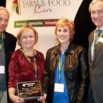Barbara Sheardown and Jayne Miller accepted the award on behalf of the Brant County committee. Also shown are Crispin Colvin, right, a current Farm & Food Care board director and past chair Bruce Christie.