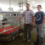 Joel Stam, with son Nathaniel, has three collectors running in his new sand-bedded barn.