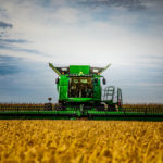 A combine moves through the field of rice near Pain Court, harvesting the first crop for Ontario FangZheng Agriculture Enterprise Inc. with Jim Hawkins and Wendy Zhang in the cab.