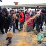 Farmers dump bags of corn grain in front of the Papineau riding office of Prime Minister Justin Trudeau in Montreal, as they protest the lack of propane due to the CN strike, on Nov. 25, 2019. (Photo: Reuters/Christinne Muschi)