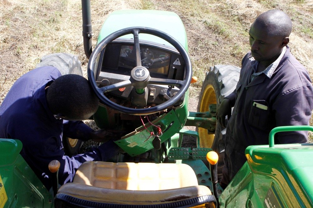 David Kayi, a Hello Tractor engineer, installs an application on a John Deere 5503 tractor, using the Hello Tractor technology that connects farmers with vehicles’ owners, at a hay farm at Umande village in Nanyuki, Kenya on Feb. 4, 2020. (Photo: Reuters/Njeri Mwangi)
