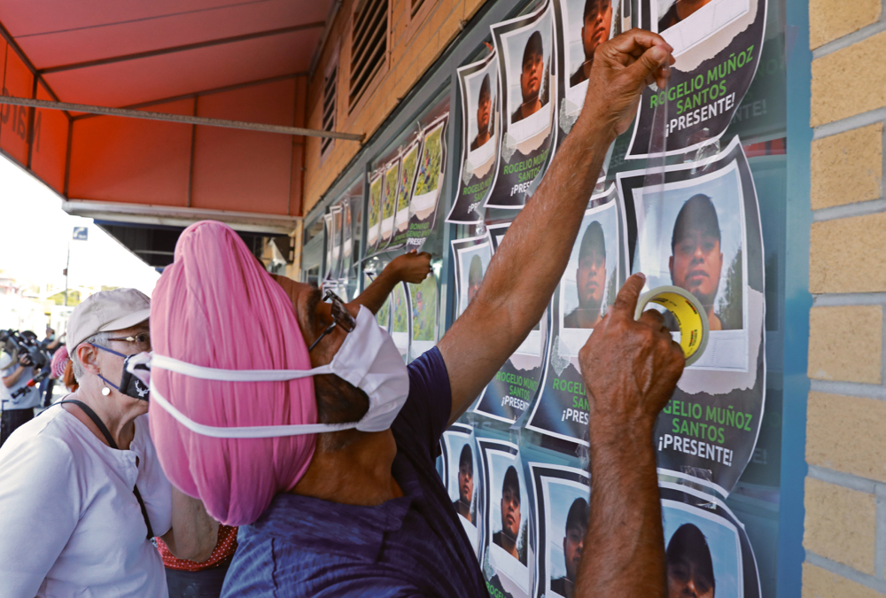Supporters tape photographs of migrant worker Rogelio Munoz Santos, who died from coronavirus disease (COVID-19), during a pro-immigration rally by migrants, refugees and undocumented workers outside the office of Canada’s Immigration Minister Marco Mendicino in Toronto on July 4.