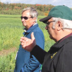Participating landowner Gord Green, foreground, discusses his family’s participation in the ONFARM soil health research initiative with Adam Hayes of the Soil Resource Group.