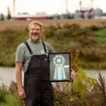 Marc Bercier with his ALUS award at his farm.