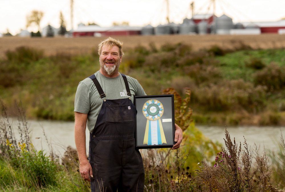 Marc Bercier with his ALUS award at his farm.
