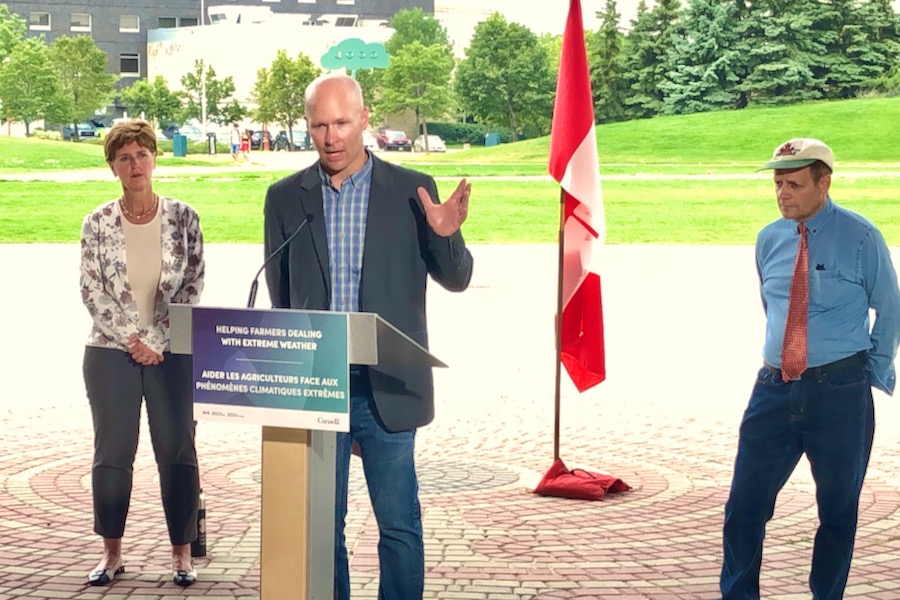 Manitoba Beef Producers president Tyler Fulton speaks in Winnipeg on July 22, 2021 at a federal/provincial announcement including planned changes to crop insurance against this summer’s drought, alongside federal Agriculture Minister Marie-Claude Bibeau and Winnipeg MP Kevin Lamoureux (r). (Dave Bedard photo)
