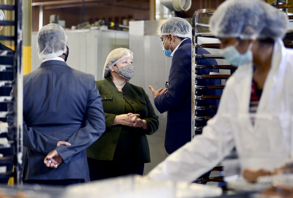 Lisa Thompson, Ontario Minister of Agriculture, Food and Rural Affairs, centre, listens as Vidhya Food Inc. president Vipul Patel, right, explains the packaging process during a tour of the Mississauga food manufacturing facility Oct. 21.