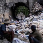 A man looks through piles of trash on a stream in Port-au-Prince, Haiti on Oct. 13, 2022. (Photo: Reuters/Ricardo Arduengo)