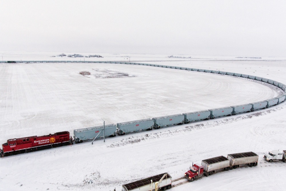 Aerial view of a loop track featuring a train of CPKC’s newer “high-efficiency” grain hopper cars, at a G3 elevator near Moose Jaw, Sask. in December 2018. (CPR.ca)
