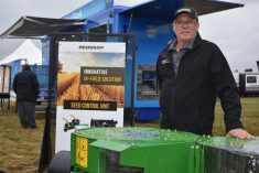 Neale Heinrich stands in front of the Redekop Seed Control Unit at its booth at Ag in Motion on July 18, 2023. (Braedyn Wozniak photo)