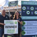 Trevor Scherman and Megan Madden hold the sign displayed in front of their ScherGain booth at Ag in Motion on July 20, 2023. Photo: Braedyn Wozniak