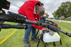 Felix Weber of Ag Business and Crop Inc. swaps an XAG P100 pro drone from an augered spreading system to a liquid tank at COFS.