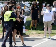 Sabrina Desgagne, New Wave Activist, is removed from the entrance of Sofina Fearmans Pork Inc. by Halton Regional Police Service Const. Barnes as she attempts to step in front of a moving livestock transport as it makes its way into the processing plant Aug. 20.