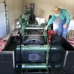 Inside his St. Marys-area machine shop, John Stutzman stands atop the 1910 Case steam engine he has spent decades restoring.