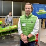John Deere's Jonathan Edwards stands in front of the company's new Active Slope Adjustment for combine cleaning shoes at Agritechnica.