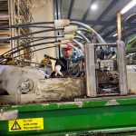 Workers watch for large clumps as the substrate is unloaded from trucks onto the growing racks, breaking up what they can.