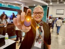 Erica Tessman of Merck Animal Health shows the SenseHub Youngstock tag that lights up when a calf has an issue that needs to be checked.