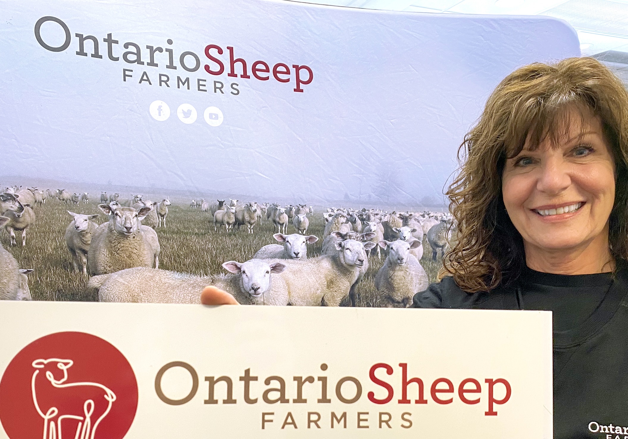 Jan Smith, Ontario Sheep Farmers administrative assistant, display's the organizaions new roadside producer sign during the annual general meeting in Cambridge, Ont., Oct. 25, 2024.
