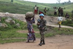 UN peacekeepers guard Congolese farmers working their fields
