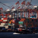 A tugboat passes shipping containers being unloaded and stacked on a pier at Port Newark, New Jersey, U.S., November 19, 2021.
Photo: Reuters/Mike Segar/File