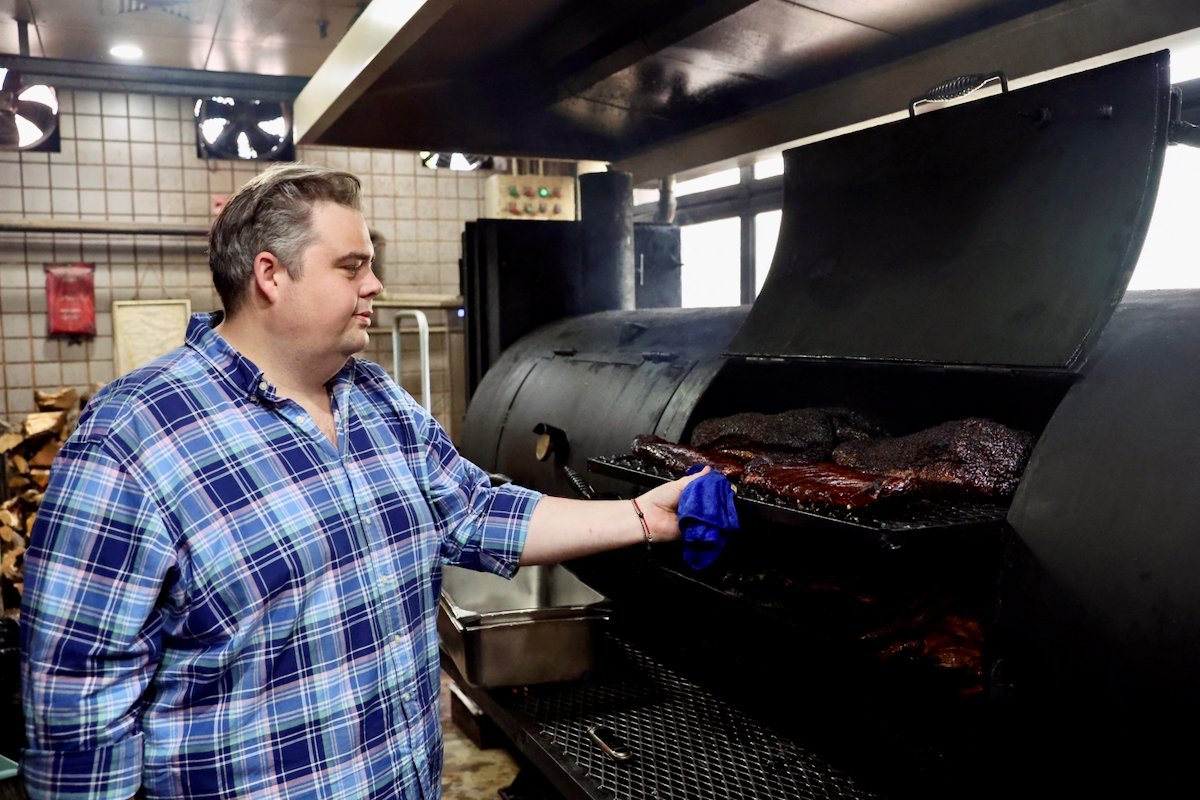 Charles de Pellette, Operations Director of the restaurant, poses for a picture next to U.S. beef and pork in a smokehouse, at Home Plate BBQ, an American-style restaurant, in Beijing, China April 17, 2025.  Photo: Reuters/Tiffany Le
