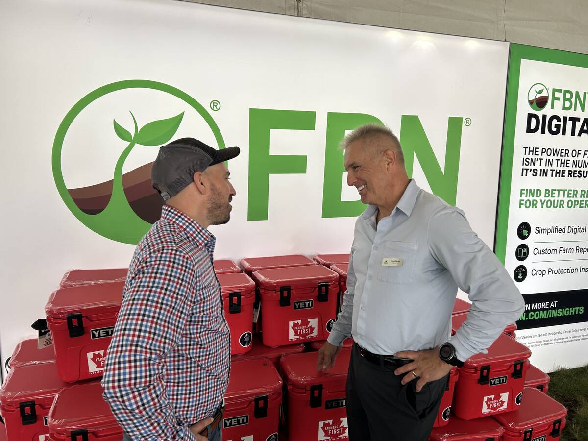 Nigel Buffone, left, Farmers Business Network’s senior director of crop protection, talks to Breen Neeser, FBN’s general manager, at the Ag in Motion show in Langham, Sask. Photo: Sean
