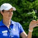 Leanne Freitag, Bayer Crop Science agronomic solutions advisor, holds a corn plant sample to help producers understand how to stage correctly during the herbicide injury scenario discussion at the Ontario Weed Tour at the Elora Research Station on July 16, 2025. Photo: Diana Martin