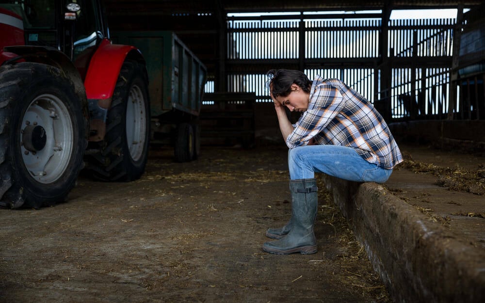 Photo of farmer who seems depressed or distraught. Photo: SolStock/istock/getty images
