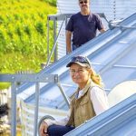 Jeannette Mongeon and Michel Dignard sit on a metal roof, overlooking a corn field in Embrun, Ontario.