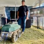 Tanya Franklin, of Upside Robotics, stands with one of the company's fertilizer robots at Canada's Outdoor Farm Show 2025. Photo: John Greig