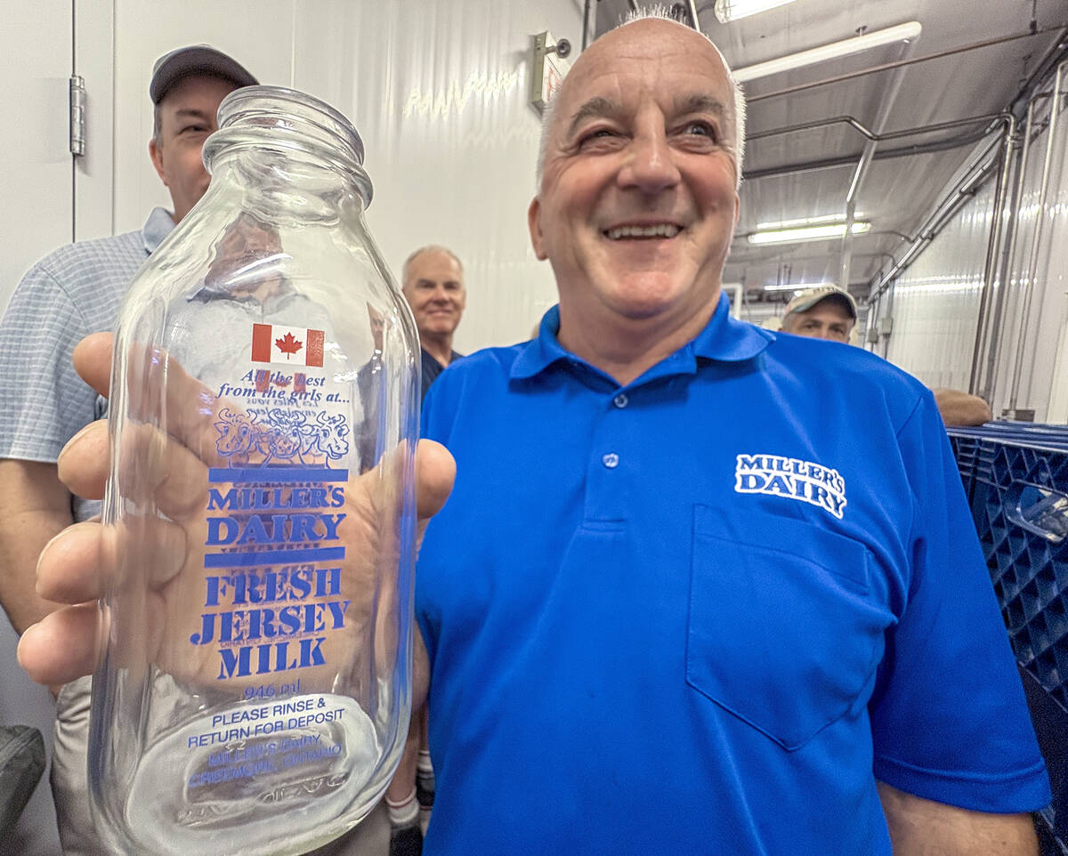 John Miller,  proudly displays the Canadian Flag that adorns the smaller sized glass bottles for their premium Jersey milk products during a tour of the on-farm processing facility near Creemore, Ont. Photo Diana Martin