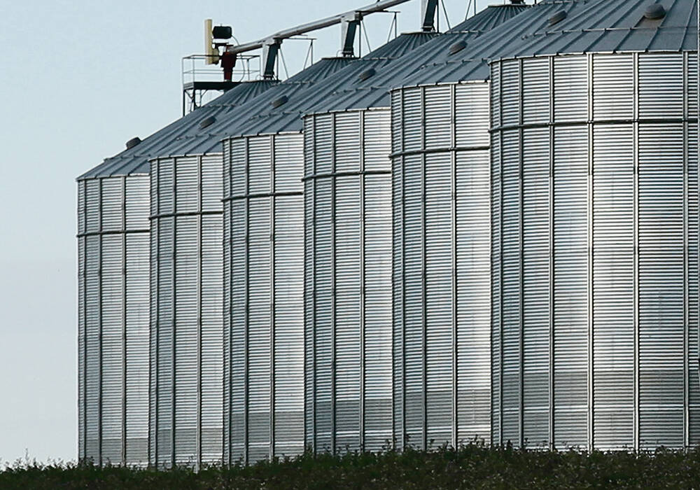 A row of six large grain bins. Photo: file