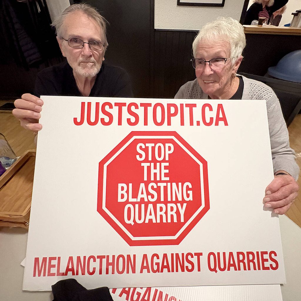 Melancthon Against Quarries (MAQ) coalition members, Rae Smith, left, of Melanchton Township, and Denise Ralph, Horning's Mills, manned a table with blast quarry protest signs and t-shirts during a Nov. 4, 2025, MAQ meeting in Horning's Mills. Photo: Diana Martin