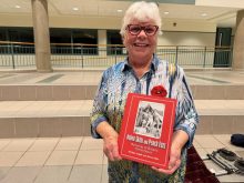 Bonnie Setter holding her book 'Onion skins and peach fuzz' at a screening of the We Lend a Hand documentary in Strathroy, Ont. Photo: John Greig