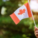 Female hand holding a Canadian flag.