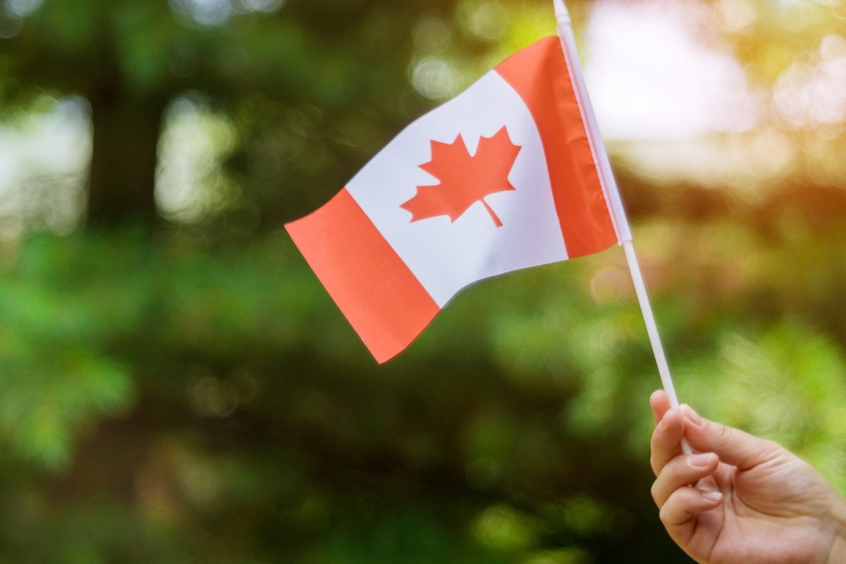 Female hand holding a Canadian flag.