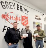 Grey County Beef Farmers Association president Matt McKinnon, left, and Bruce County Beef Farmers president Calvin Anstett, right, beef up Grey Bruce Food Share volunteer Pat McDonough's, centre, day by donating a collective $4,000 to the program. Contributed photo