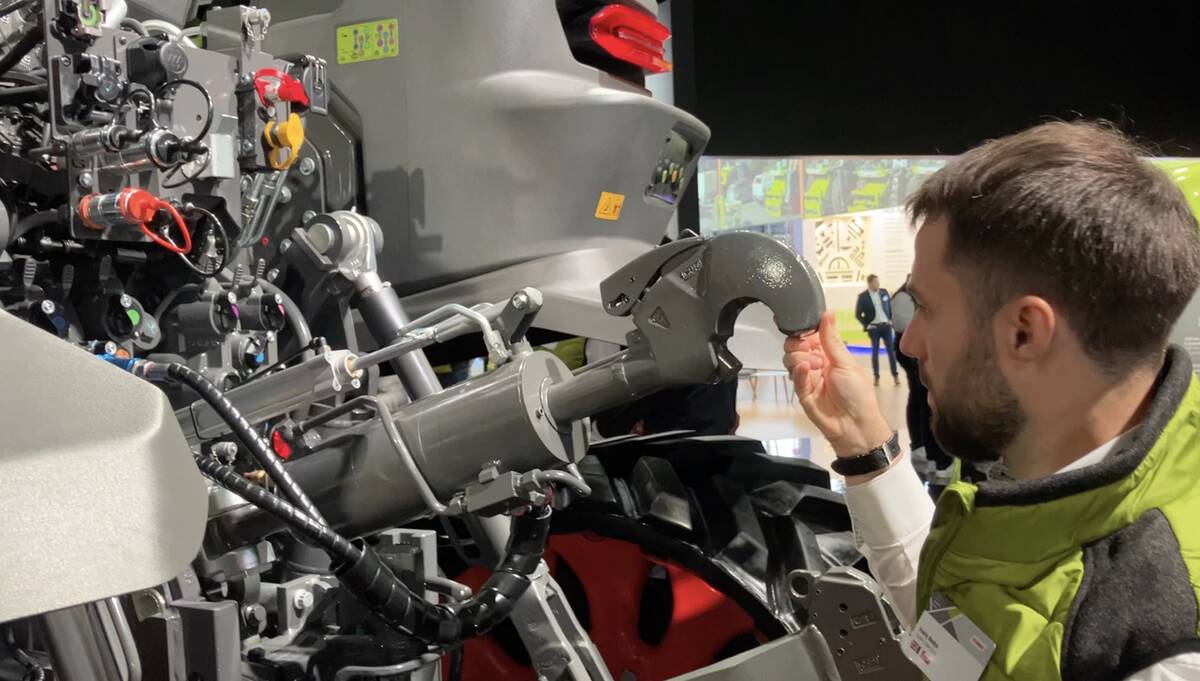 Vasily Badya, Claas product manager for Axion tractors, demonstrates how it only takes two fingers to raise or lower the heavy top link on the Axion 9.450 tractor. The near effortless task is achieved by a weight compensator mechanism. Photo: Greg Berg