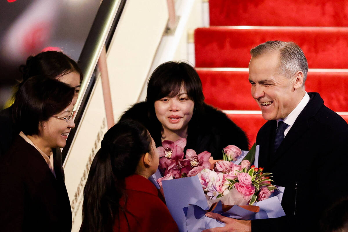 Canada&rsquo;s Prime Minister Mark Carney receives flowers from Lu You Ci, 11, upon his arrival at Beijing Capital International Airport, during the first visit by a Canadian Prime Minister to China since 2017, in Beijing, China January 14, 2026.  Photo: REUTERS/Carlos Osorio
