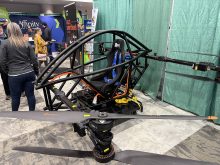 A large drone with 8 propellers and a passenger seat on display at the 2026 Western Canadian Crop Production Show in Saskatoon.