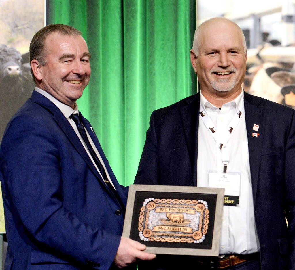 Jason Leblond, incoming Beef Farmers of Ontario president, left, presents Craig McLaughlin, out going president, with a mock-up of the belt buckle the organization had made to mark his nine-years on the board. Photo: Diana Martin