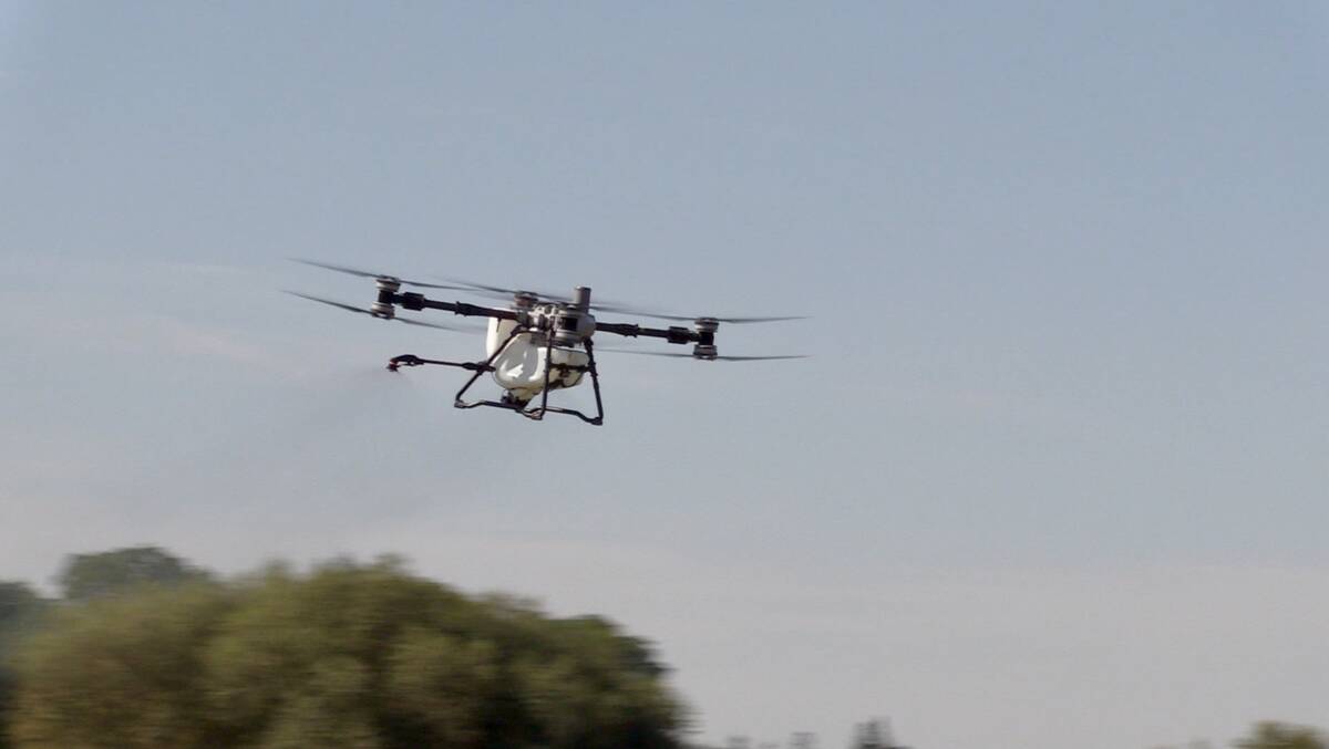 The DJI Agras T100 drone flies through the air during a demonstration at Canada’s Outdoor Farm Show in Woodstock, Ont. Photo: Greg Berg

