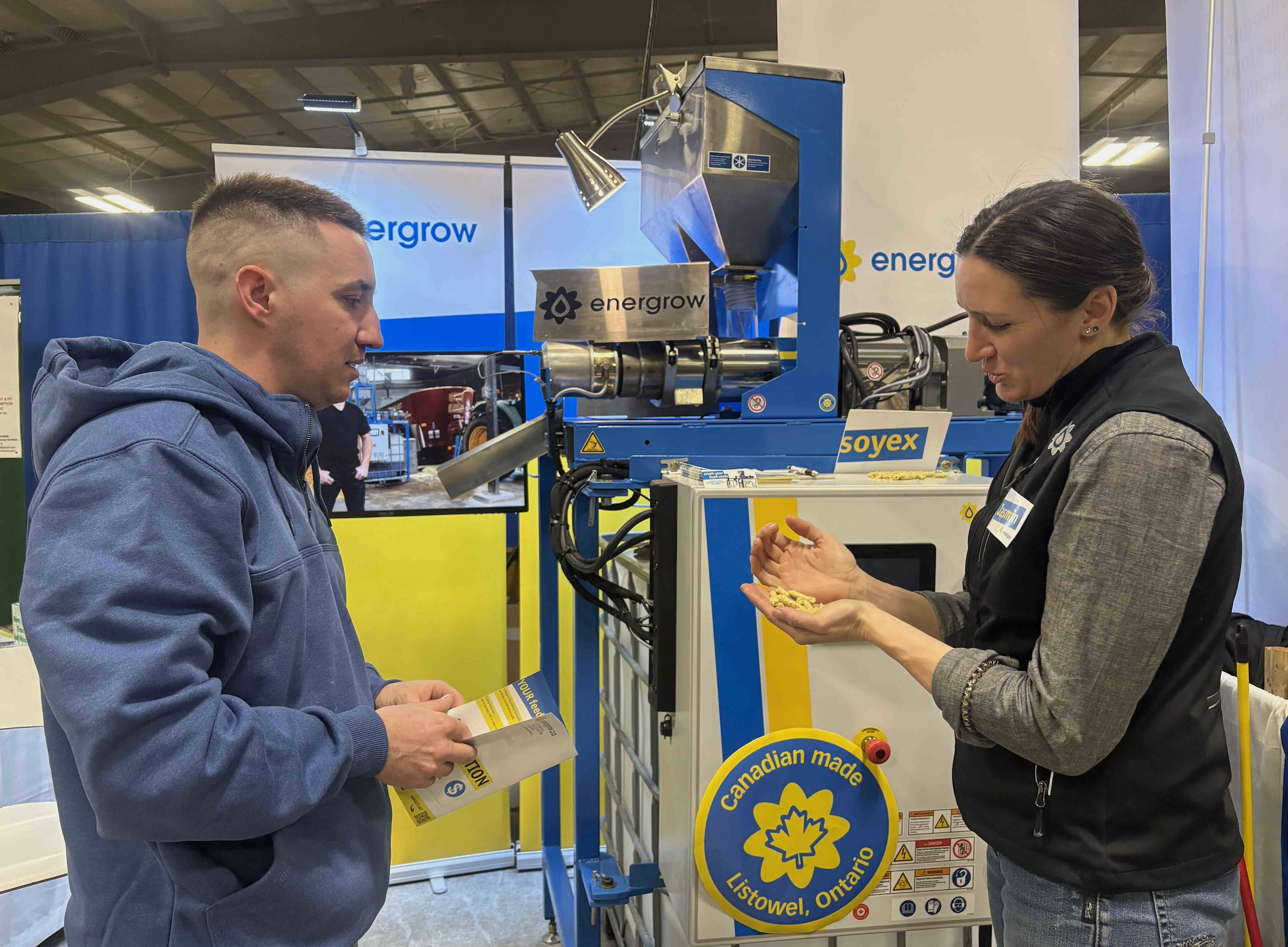 Devon Clark of St. Marys learns about on farm oil-press technology from Energrow president and CEO Jasmin Hofer at the 42 annual Drayton Farm Show. Photo: Sarah McGoldrick