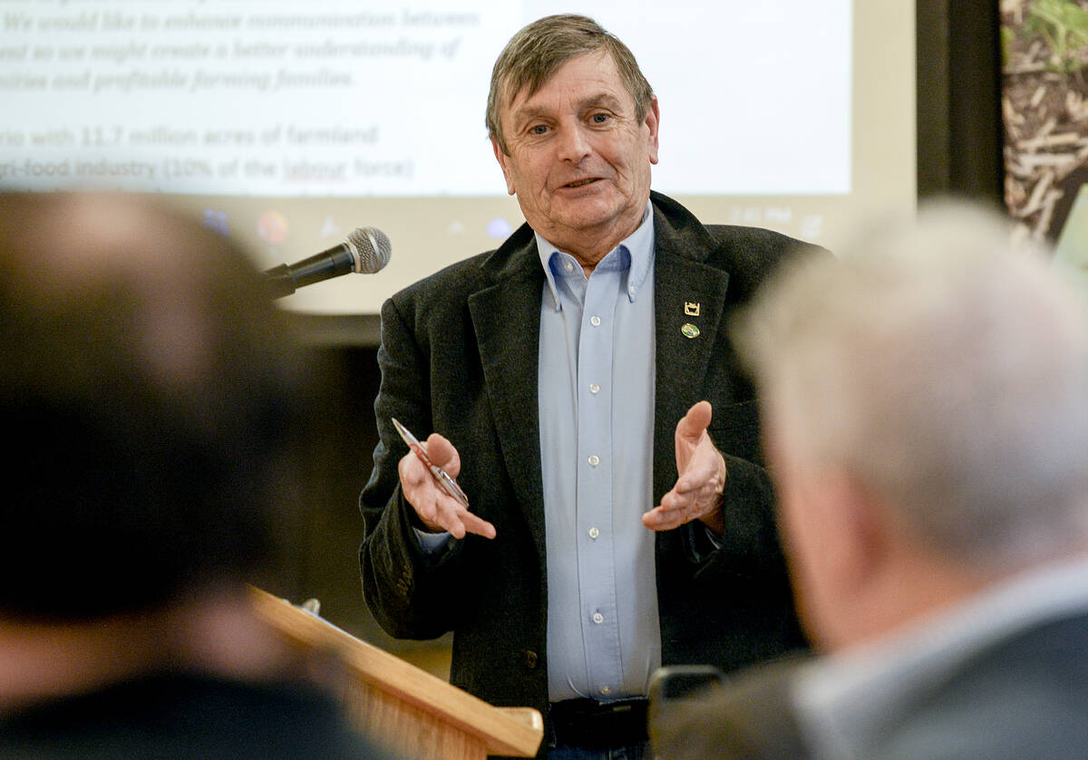 Brian Gilroy, Ontario Fruit and Vegetable Growers Association representative and Meaford-area apple grower, dressed in a blue button-down shirt and a dark blazer, gestures towards the audience, his hands open and facing upwards. Photo: Diana Martin.